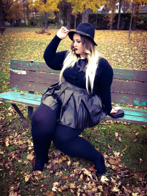 plus size goth witchy outfit with leather skirt, black top, and fedora