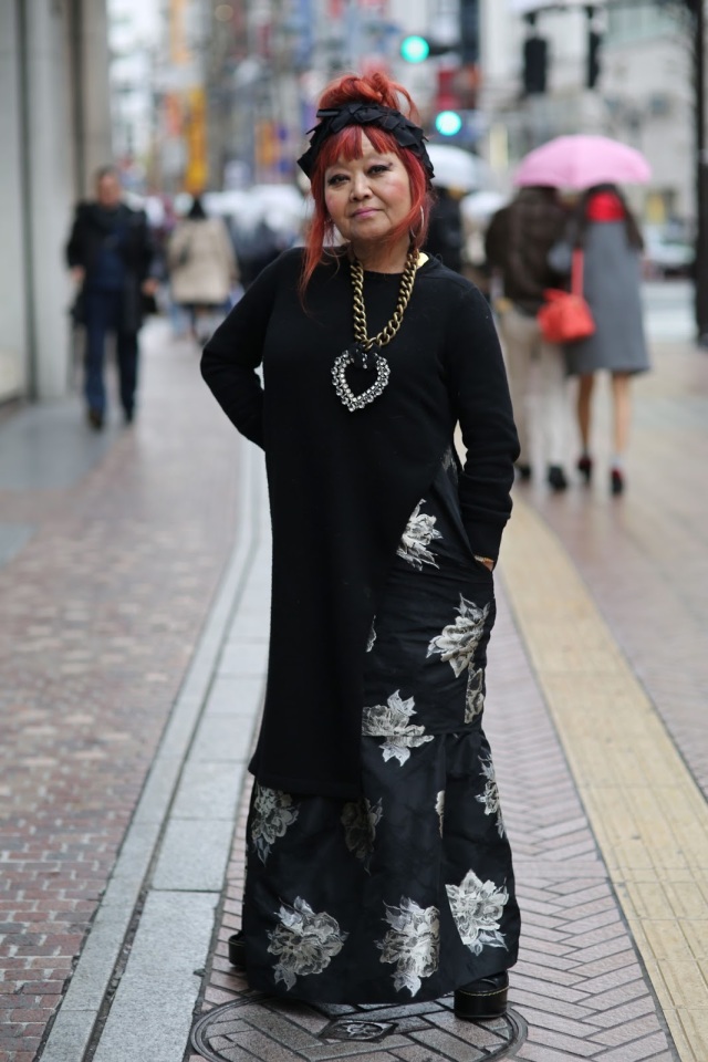 older woman wearing black tunic and black and gray rose skirt