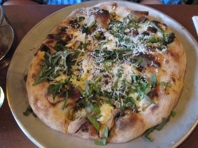 Pizza with broccoli, lemon, goat cheese, garlic, mushrooms, and basil
